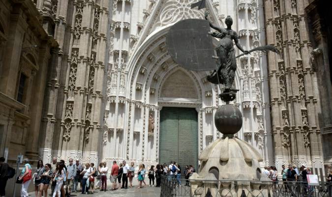 Grupos de turistas aguardan su entrada en la Catedral de Sevilla. 
