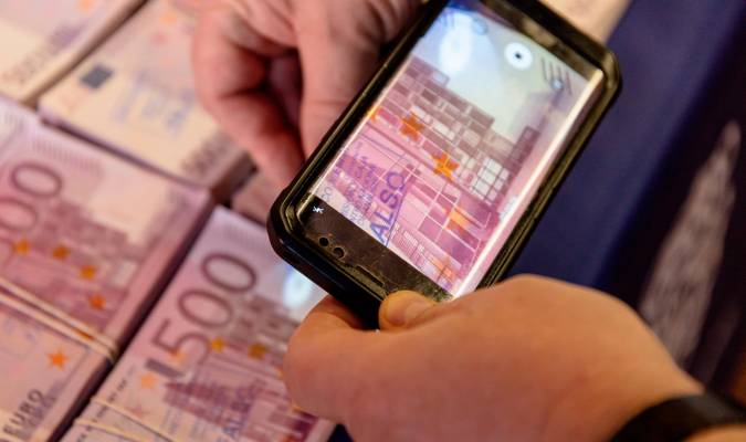 Un móvil fotografía un billete falso de 500€ en una rueda de prensa de la Policía Nacional y los Mossos d’Esquadra. Carlos Luján / Europa Press 