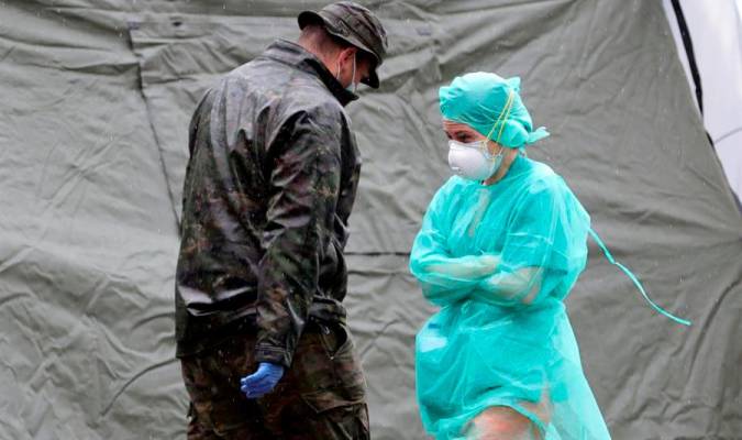 Una sanitaria pasa junto a un militar ante un hospital de campaña montado cerca del acceso de Urgencias del Hospital Gregorio Marañón, este martes, en Madrid. EFE/JuanJo Martín