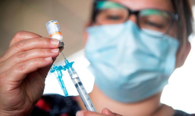 Una sanitaria prepara una vacuna contra la covid. / EFE - Joédson Alves