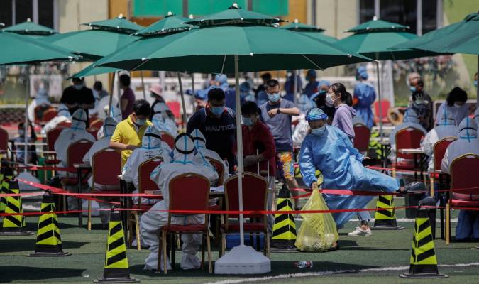 Varias personas hacen cola para hacerse el test de coronavirus en el pabellón deportivo de Beijing, China, el lunes pasado. EFE/Stringer