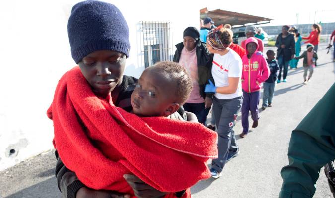 Un joven lleva en brazos a un bebé a su llegada al puerto de Motril (Granada). EFE/ Miguel Paquet