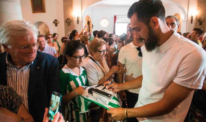 Borja Iglesias firmando una camiseta en la ofrenda floral en la Iglesia de Santa María de la Estrella de Coria del Río (Sevilla). Foto: @RealBetis