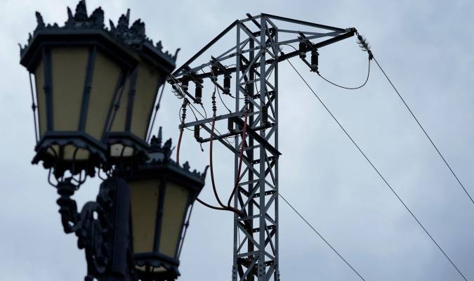 Una farola junto a una torreta de la luz. EFE/Paco Paredes