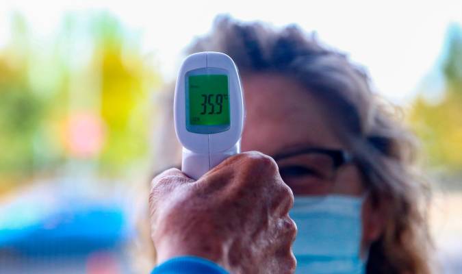 Un sanitario le toma la temperatura a una mujer. / Ricardo Rubio - E.P.