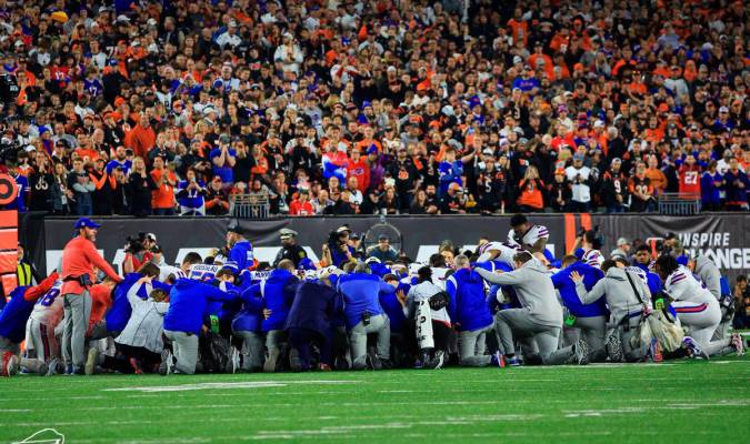 Jugadores de los Bills rezando tras los hechos en el campo.