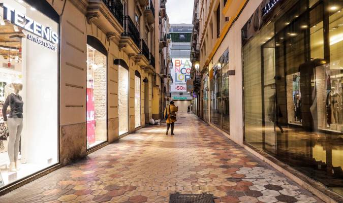 Una calle comercial de Valencia con todos sus establecimiento cerrados el primer día del cierre total de la hostelería y de tiendas a las 18.00. / E.P.