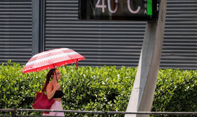 Fotografía de archivo, tomada el pasado 14 de noviembre, en la que se registró a una mujer al protegerse del sol bajo una sombrilla en una avenida de Sao Paulo (Brasil), dónde los termómetros urbanos registraron una temperatura de 40 grados centígrados. EFE/Sebastião Moreira