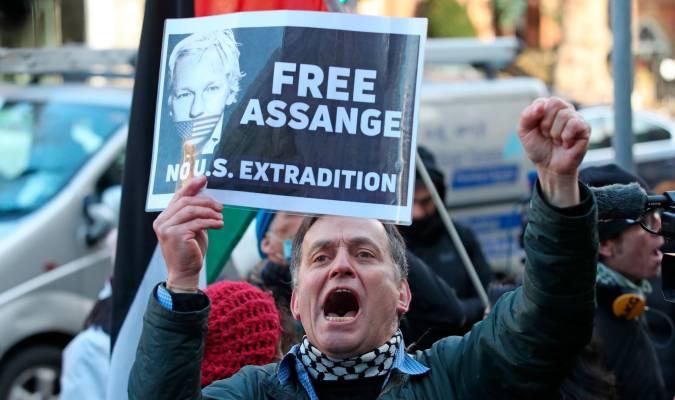 Un partidario del fundador de Wikileaks, Julian Assange, sostiene un cartel fuera del Tribunal Penal Central.