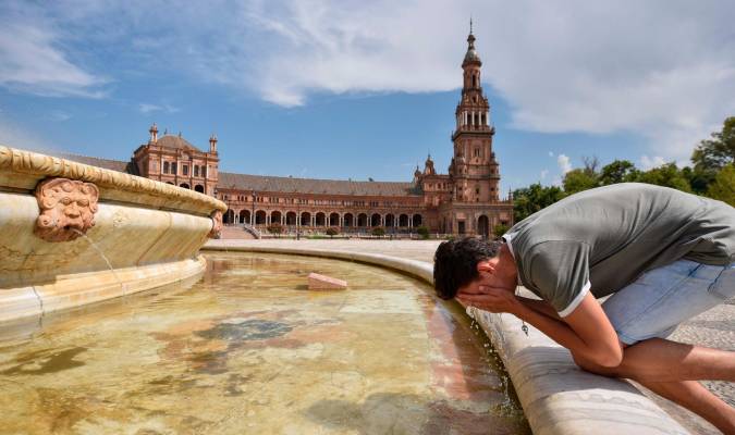 Un viandante se refresca en la fuente de la Plaza de España. / Jesús Barrera
