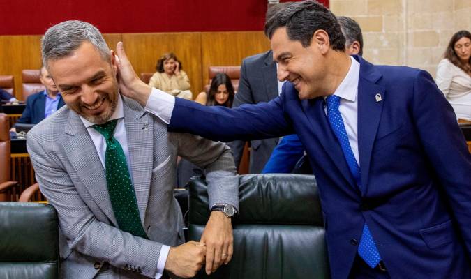 El presidente andaluz, Juanma Moreno, bromea con el consejero de Hacienda, Juan Bravo. EFE/Julio Muñoz