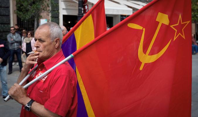 Un manifestante con las banderas republicana y del Partido Comunista espera fumando la salida de la manifestación del Primero de Mayo en Sevilla, en 2018. EFE/Julio Muñoz