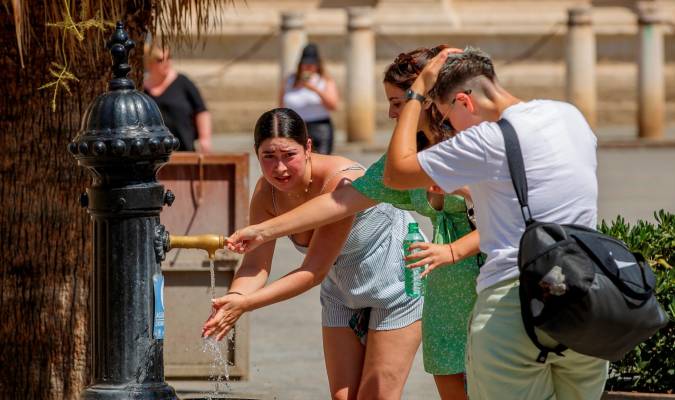 Imagen de archivo de varios turistas refrescándose en una fuente de agua junto a la Catedral de Sevilla. EFE/Julio Muñoz