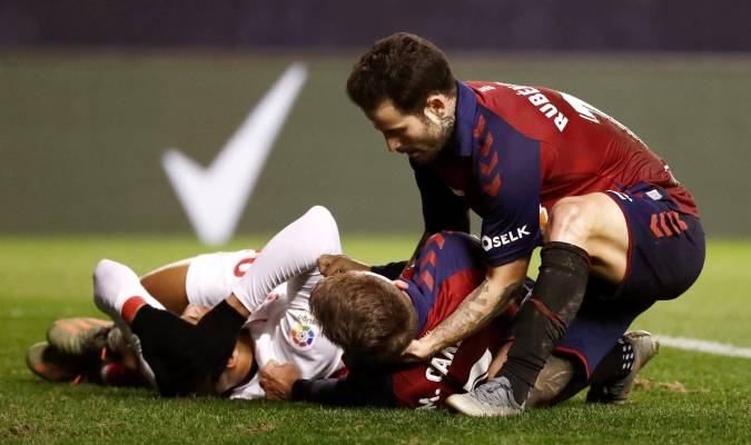 El jugador de Osasuna Rubén García (d) acude en ayuda de su compañero Marc Cardona (c) que cayó al suelo tras un encontronazo con un jugador del Sevilla. EFE/Jesús Diges