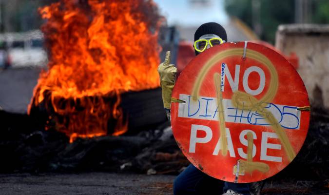 Un manifestante sostiene un aviso durante una protesta hoy en Cali (Colombia). EFE/ Ernesto Guzmán Jr
