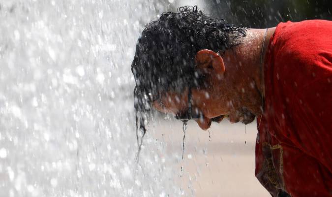 Un hombre se refresca en una fuente pública del centro de Córdoba . EFE/Salas