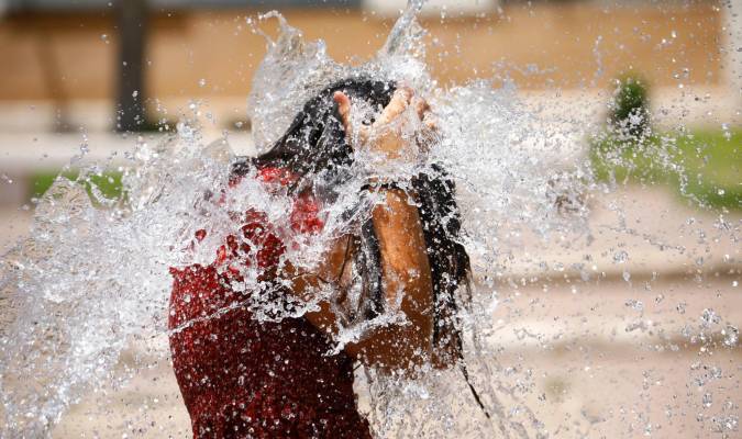 Una niña juega en una de las fuentes de Córdoba para aliviar las altas temperaturas. EFE/Salas