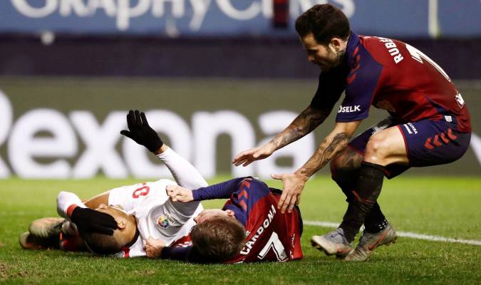 El jugador de Osasuna Rubén García (d) acude en ayuda de su compañero Marc Cardona (c) que cayó al suelo tras un encontronazo con un jugador del Sevilla. EFE/Jesús Diges