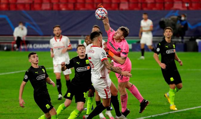 El portero del Krasnodar Ayvey Safonov (2d), intenta despejar ante el centrocampista argentino del Sevilla Lucas Ocampos (3i). EFE/Julio Muñoz