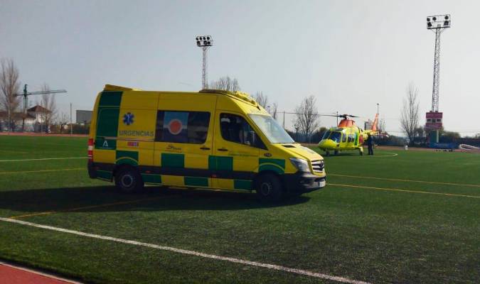La ambulancia en la que ha sido evacuado el niño, junto al helicóptero en el polideportivo de Lepe.