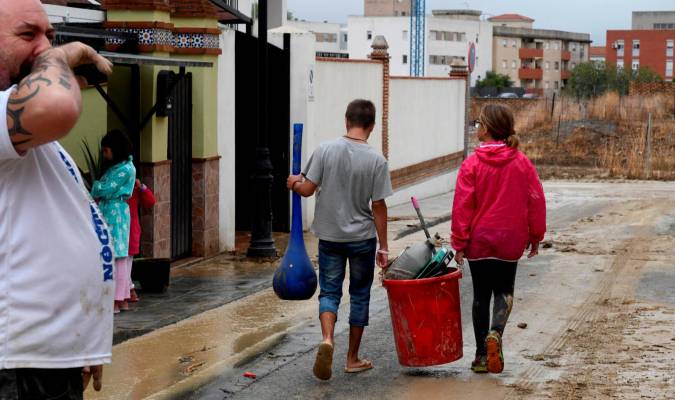 Vecinos, bomberos y Proteccion Civil achican agua en la población de Las Gabias (Granada). EFE/Miguel Angel Molina