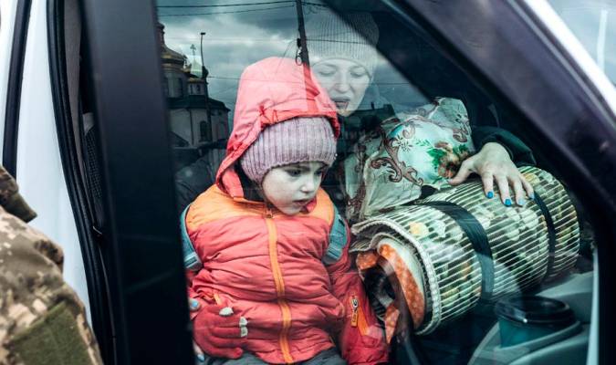 Una madre y su hija en un coche de evacuación en Irpin (Ucrania). / E.P.