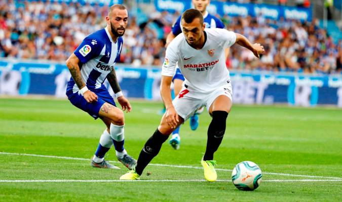 El centrocampista del Sevilla Joan Jordán (d) controla el balón ante la mirada de Aleix Vidal (i), del Deportivo Alavés. EFE/David Aguilar