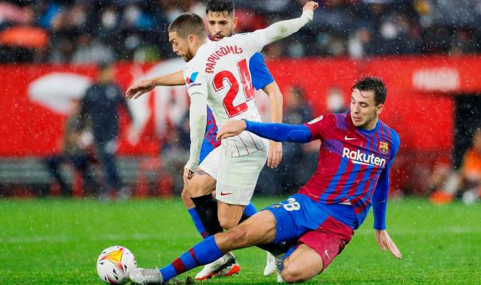 El delantero argentino del Sevilla Papu Gómez (i) pelea un balón con Nico González, del FC Barcelona. / EFE/Jose Manuel Vidal