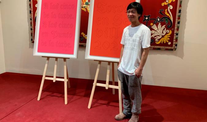 El creador vietnamita Danh Vö posa con los carteles que ha pintado para la Maestranza. Foto: Toromedia
