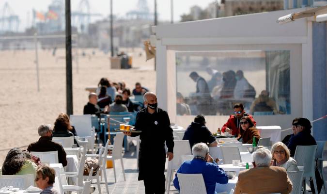 Un camarero atiende las mesas de una terraza en uno de los restaurantes de la playa de la playa de la Malvarrosa de Valencia. EFE/Manuel Bruque