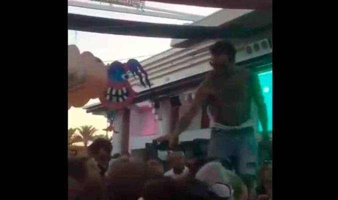 Fragmento del vídeo donde se ve a un DJ dando alcohol de la misma botella a varios asistentes. Previamente, les había escupido.