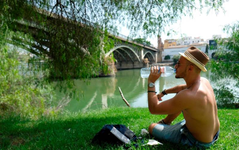 Un turista se refresca en Sevilla. / EFE
