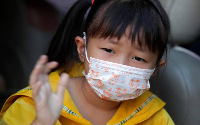 Una niña se protege con una mascarilla del coronavirus. / EFE