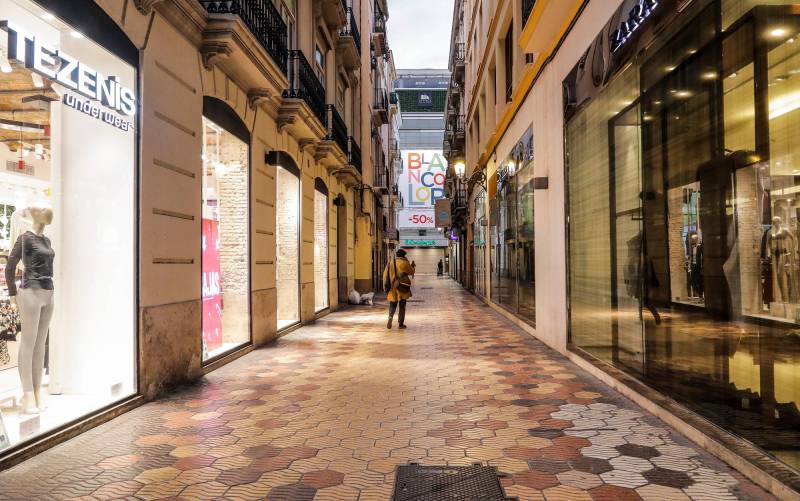Una calle comercial de Valencia con todos sus establecimiento cerrados el primer día del cierre total de la hostelería y de tiendas a las 18.00. / E.P.