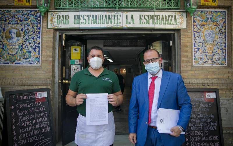 El propietario del bar La Esperanza, Jesús Noguera (i) y su abogado Germán Grima en la puerta del establecimiento. / María José López - E.P.