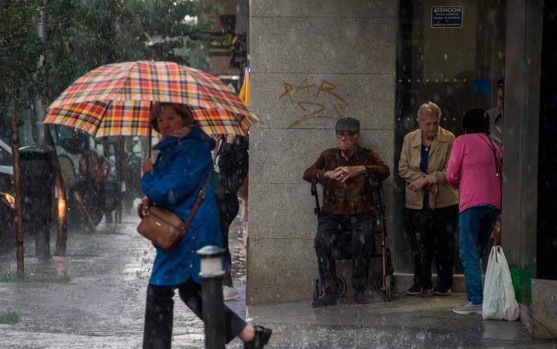 Una mujer con paraguas bajo la lluvia. / E.P.