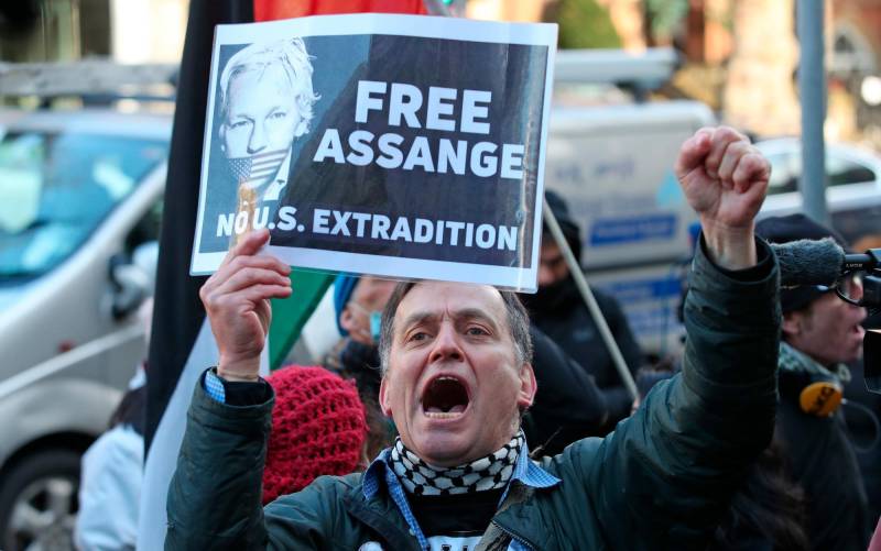 Un partidario del fundador de Wikileaks, Julian Assange, sostiene un cartel fuera del Tribunal Penal Central.