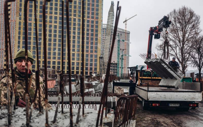 Varios operarios cargan losas de cementoen Kiev (Ucrania). / E.P.