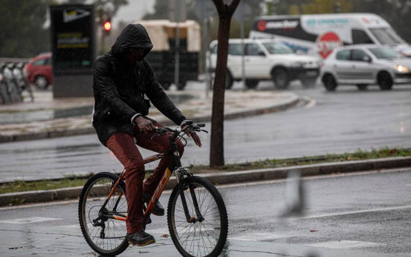 Un hombre circula en bicicleta bajo la lluvia. . / E.P.