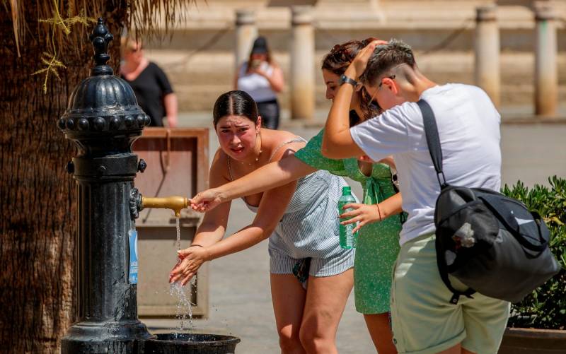 Imagen de archivo de varios turistas refrescándose en una fuente de agua junto a la Catedral de Sevilla. EFE/Julio Muñoz