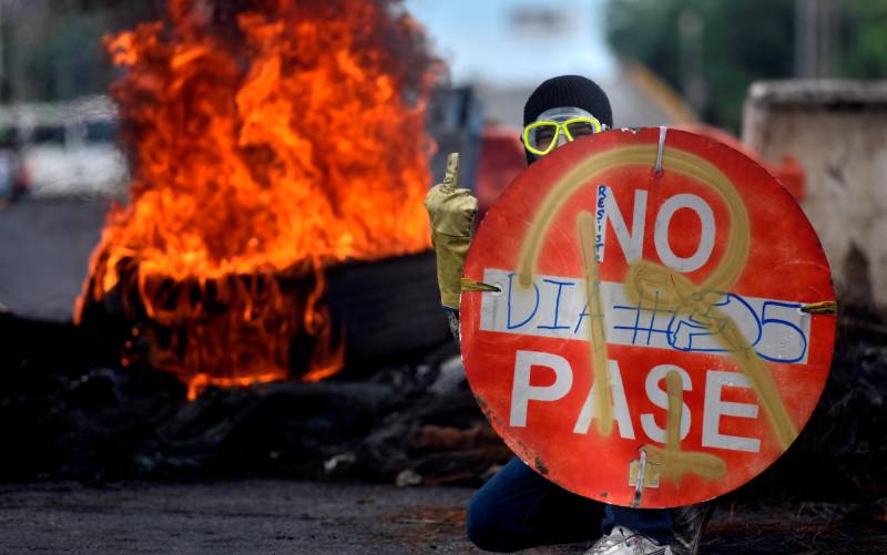Un manifestante sostiene un aviso durante una protesta hoy en Cali (Colombia). EFE/ Ernesto Guzmán Jr