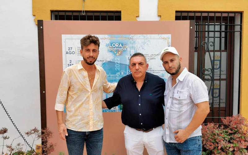 Juanlu Montoya, que ofrecerá un concierto el próximo día 3 de septiembre, acompañado por el concejal de Cultura, Miguel Ángel Nogales, y el rapero Sica (Foto: Ayuntamiento de Lora del Río).