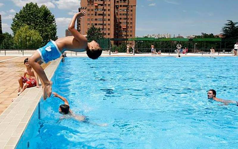 Un niño se lanza a una piscina. / EFE