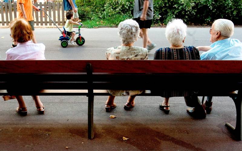 Pensionistas sentados en un parque.