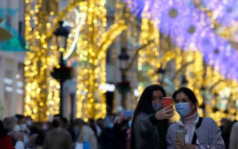 Dos mujeres se retratan en una abarrotada calle Larios de Málaga con motivo de las luces de Navidad / Efe - Álex Zea