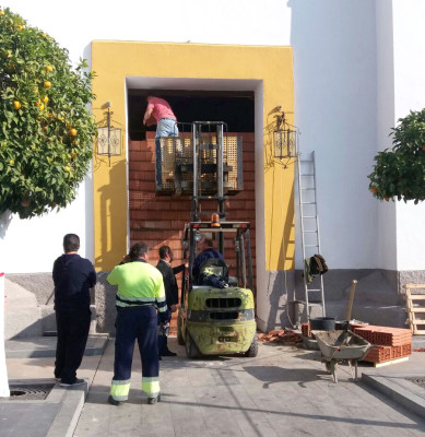 Operarios tapian el vano de la puerta de la Parroquia de la Granada, horas después de ser retiradas las puertas destrozadas por el ‘alunizaje’. / Manuel García
