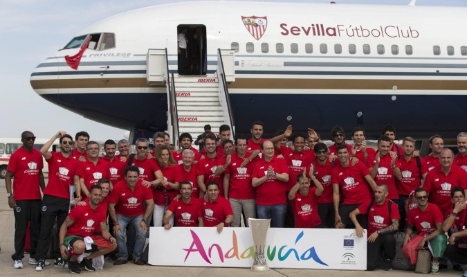 La plantilla del Sevilla posa en la pista del Aeropuerto de San Pablo. / Julio Muñoz / Efe