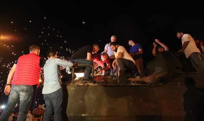Varios ciudadanos intentan sacar de un tanque a los militares que se han encerrado en él. / Efe